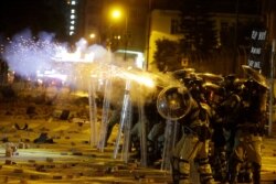 Police in riot gear fire tear gas at protesters near Hong Kong Polytechnic University in Hong Kong, Nov. 16, 2019.