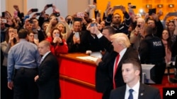 President-elect Donald Trump gives a thumbs-up to the crowd as he leaves the New York Times building following a meeting, Nov. 22, 2016, in New York. 