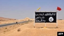 FILE - An Islamic State group poster is seen in the Syrian town of al-Sukhnah, Aug. 13, 2017.