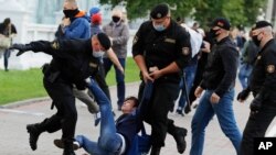 Police officers detain a protester during a rally against the removal of opposition candidates from the presidential elections in Minsk, Belarus, July 14, 2020.
