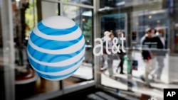 FILE - The AT&T logo is seen on an AT&T Wireless retail storefront in Philadelphia. 