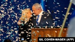 Perdana Menteri Israel Benjamin Netanyahu dan istrinya, Sara, di tengah taburan confetti saat berbicara di depan para pendukungnya, di kantor pusat Partai Likud, di Tel Aviv, 3 Maret 2020.