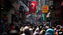 FILE - In this Friday, March 24, 2017 file photo, people fill an open market in the historic Sultanahmet district of Istanbul. (AP Photo/Lefteris Pitarakis, file)