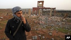 A rebel walks inside a destroyed weapons dump near Benghazi, March 5, 2011