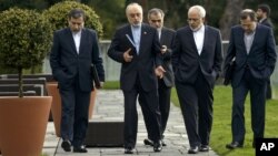 Head of the Iranian Atomic Energy Organization, Ali Akbar Salehi, second from left, and Iranian Foreign Minister Javad Zarif, second from right, walk together during negotiations at a hotel in Lausanne, Switzerland, March 29, 2015. 