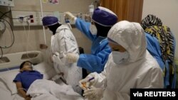 FILE - Nurses take a sample from Parham, a 7-year-old, to test for the coronavirus disease (COVID-19), at a hospital, in Tehran, Iran, July 8, 2020. (West Asia News Agency)