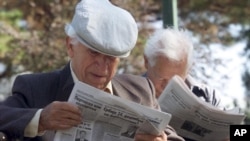 Penzioneri čitaju novine u parku u Beogradu (Foto: AP/Darko Vojinović)