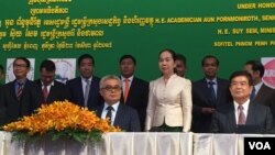 រដ្ឋមន្ត្រីក្រសួង​សេដ្ឋកិច្ច​ និងហិរញ្ញវត្ថុ​ លោក​ អូន ព័ន្ធមុនីរ័ត្ន​ នៅ​ខាង​ឆ្វេងដៃ​ និង​រដ្ឋមន្ត្រី​ក្រសួង​រ៉ែ​ និង​ថាមពល​ លោក​ ស៊ុយ​ សែម​ នៅ​ខាង​ស្តាំ​ដៃ​​ កាលពី​ថ្ងៃ​ទី​ ២៣​ ខែ​ សីហា​ ឆ្នាំ​ ២០១៧​ ចូលរួម​ពិធី​ចុះហត្ថលេខា​លើ​កិច្ច​ព្រមព្រៀង​ប្រេងកាត​ស