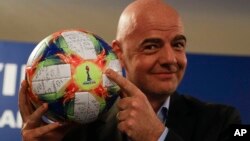 FIFA President Gianni Infantino holds the official ball of the upcoming Women's Soccer World Championship during a press conference at the end of an executive committee meeting in Rome, Feb. 27, 2019.