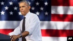 President Barack Obama pauses while speaking about the economy, July 9, 2014, at Cheesman Park in Denver.