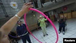 File - Patients with Alzheimer's and dementia during a therapy session inside the Alzheimer foundation in Mexico City. 