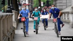 Nurses wearing face masks and riding bicycles arrive outside of Downing Street to demonstrate in a protest organised by Nurses United over pay and conditions, following the outbreak of the coronavirus disease (COVID-19), London, Britain, June 3, 2020. 
