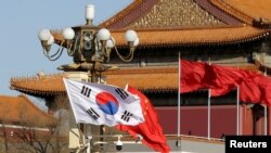 FILE - South Korea's and China's flags flutter next to Tiananmen Gate during the visit of then-South Korean President Moon Jae-in in Beijing, Dec. 15, 2017. 