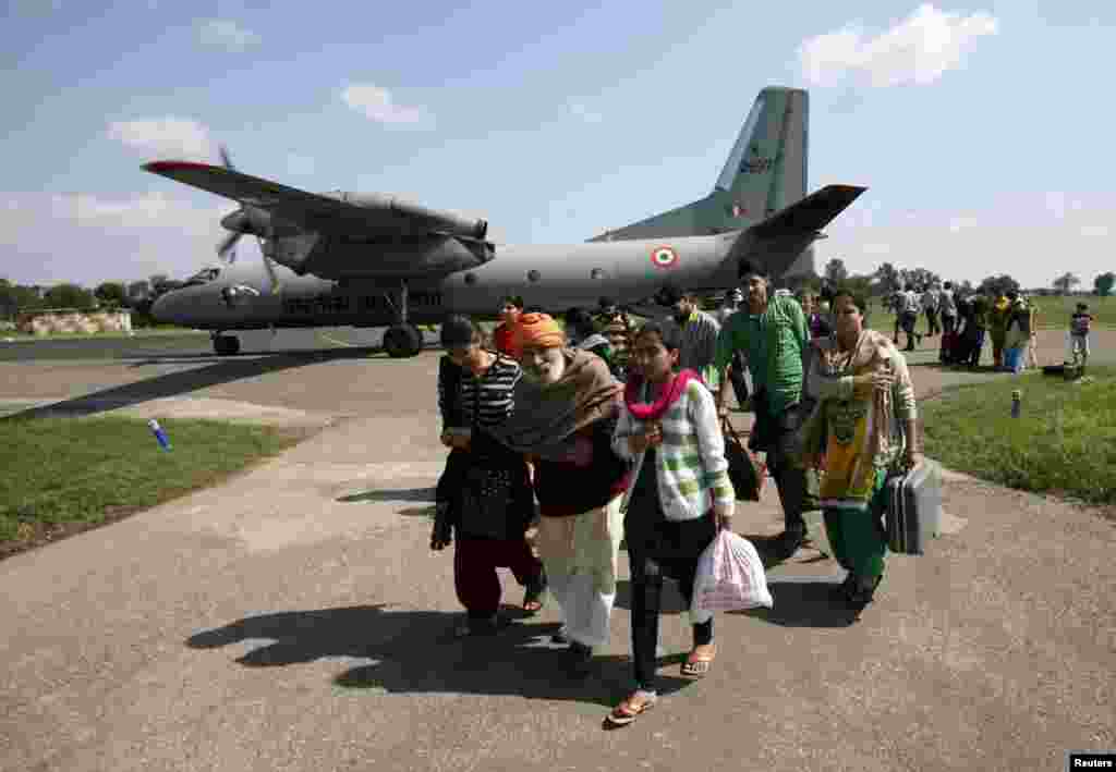 Evacuees from Srinagar city walk past an Indian Air Force AN-32 aircraft in Jammu, Sept. 9, 2014.