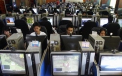 FILE - People use computers at an internet cafe in Kunming, China.