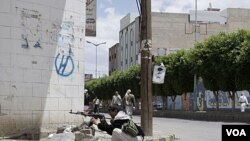 Pendukung kepala suku Hashid siaga dengan senjata AK-47 dalam bentrokan dengan pasukan pemerintah Yaman di Sana'a (24/5).