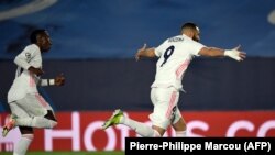 L'attaquant français du Real Madrid Karim Benzema (d) célèbre son but lors lors du match retour entre le Real Madrid CF et l'Atalanta au stade Alfredo di Stefano de Valdebebas, à la périphérie de Madrid le 15 mars 2021.