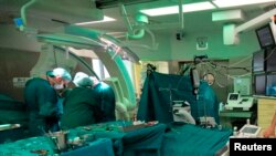 FILE - An undated picture show surgeons during a pacemaker implantation at the German Heart Institute Berlin (DHZB) in Berlin, Germany.