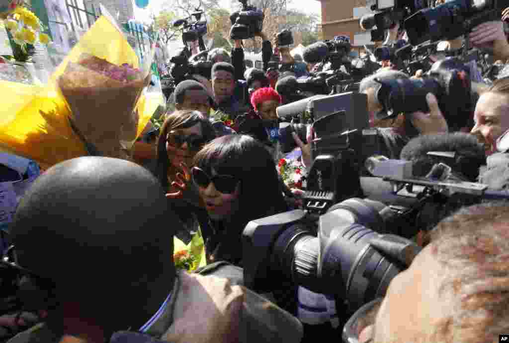 Granddaughters Zaziwe Dlamini-Manaway and Tukwini Mandela are surrounded by the media outside the Mediclinic Heart Hospital in Pretoria, June 27, 2013. 