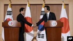 윤병세 한국 외교부 장관(오른쪽)과 기시다 후미오 일본 외무상이 28일 한국 외교부에서 공동기자회견을 가진 후 악수하고 있다.