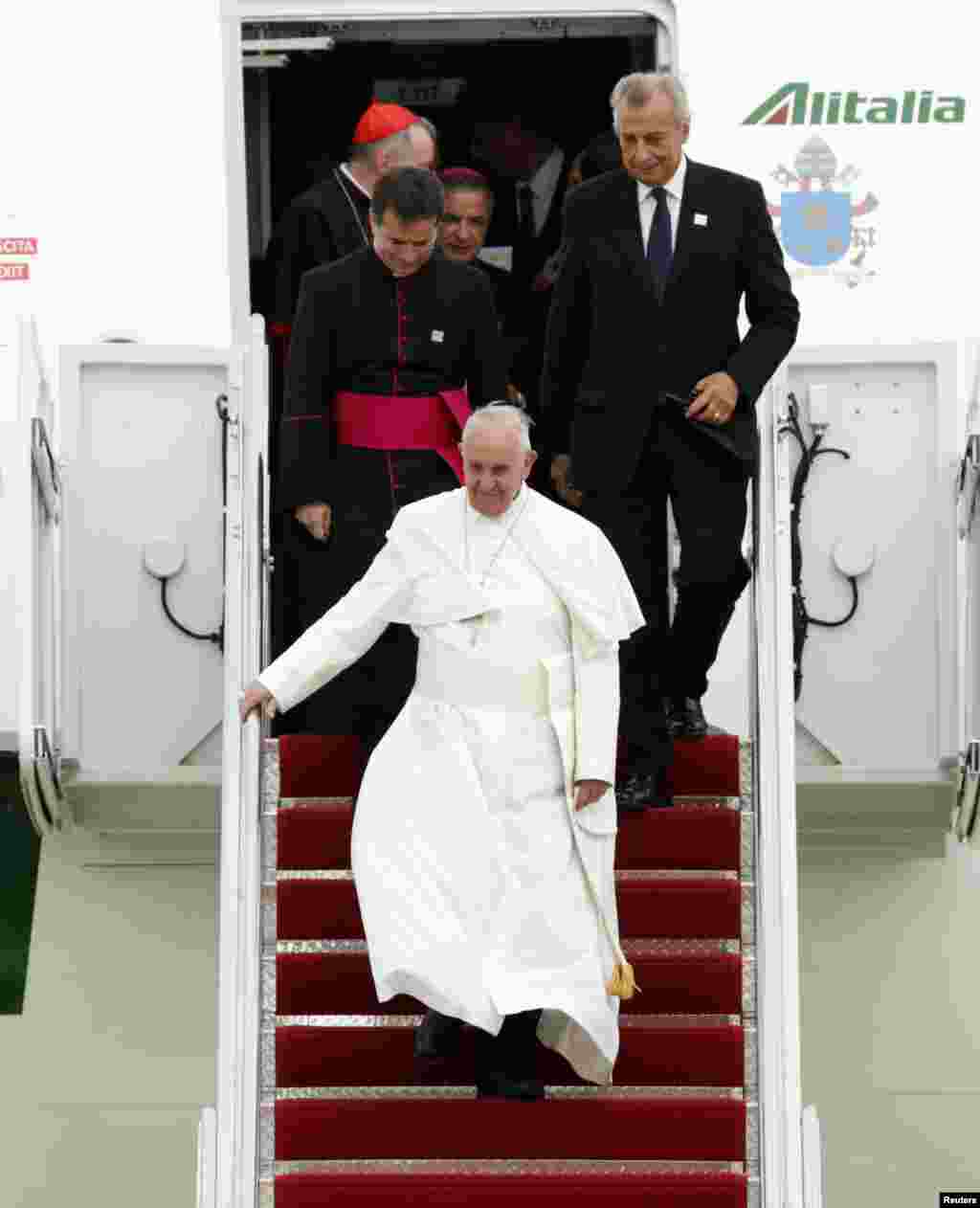 Paus Fransiskus menuruni tangga pesawat saat tiba di Maryland (22/9). (Reuters/Kevin Lamarque)