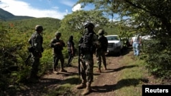 Soldiers guard an area where a mass grave was found, in Colonia las Parotas on the outskirts of Iguala, in Guerrero, Mexico, Oct. 4, 2014.