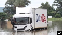 Mtu aliyesimama kwenye sehemu ya gari la kubeba mizigo akijiokoa kutokana na mafuriko Ladysmith, KwaZulu Natal, Jan 17 2022. PICHA: AP