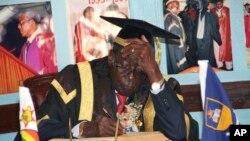 In this Friday Oct. 2, 2015 photo, Zimbabwean President Robert Mugabe writes his comments in a visitors' book at the University of Zimbabwe in Harare.