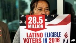 Georgina Arcienegas holds a sign in support of Latino voters during a protest outside the office of Florida Rep. Carlos Trujillo, Jan. 12, 2016, in Doral, Fla. 