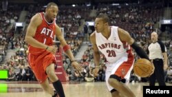 Tracy McGrady (kiri) dalam sebuah pertandingan basket NBA di Toronto (Foto: dok). Tracy McGrady akan segera bergabung dengan Asosiasi Basket Tiongkok, Qingdao DoubleStar Eagles, yang menawarkan kontrak satu tahun untuknya. 