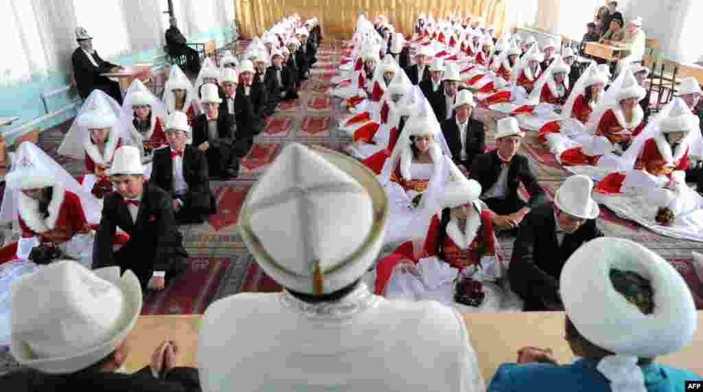 Pasangan pengantin Kyrgyz berdoa di masjid besar dalam upacara pernikahan massal di ibukota Bishkek, Kirgistan.