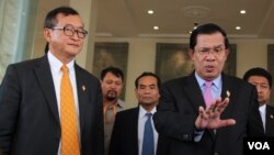 រូបឯកសារ៖ លោក​នាយក​រដ្ឋ​មន្រ្តី​ហ៊ុន​ សែន និយាយ​ទៅ​កាន់​ក្រុម​សារព័ត៌មាន​ ដោយ​មាន​លោក​​សម​ រង្សី​ ប្រធាន​គណបក្ស​សង្គ្រោះ​ជាតិ​ឈរ​អម​នៅ​មុខ​​រដ្ឋសភាជាតិ​ នៅ​​រាជធានី​ភ្នំពេញ​ កាល​ពី​ថ្ងៃ​ទី​៩​ ខែ​មេសា​ ឆ្នាំ​២០១៥។​​ (នូវ​ ពៅ​លក្ខិណា/VOA)