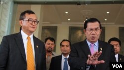 រូបឯកសារ៖ លោក​នាយក​រដ្ឋមន្រ្តី ហ៊ុន សែន និយាយ​ទៅ​កាន់​ក្រុម​អ្នកសារព័ត៌មាន​ ដោយ​មាន​លោក សម រង្សី ដែល​នៅ​ពេល​នោះ​ជា​ប្រធាន​គណបក្ស​សង្គ្រោះ​ជាតិ​ឈរ​អម​នៅ​មុខ​រដ្ឋសភា​ជាតិ​ក្នុង​រាជធានី​ភ្នំពេញ កាលពី​ថ្ងៃទី៩ ខែមេសា ឆ្នាំ២០១៥។ (វីអូអេ)