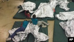 In this photo provided by U.S. Customs and Border Protection, people who've been taken into custody related to cases of illegal entry into the United States, rest in one of the cages at a facility in McAllen, Texas, June 17, 2018. 