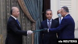 Presiden Irak Barham Salih (kiri) menyerahkan dokumen kepada Perdana Menteri baru, Mustafa al-Kadhimi di Baghdad, Irak, 9 April 2020. (Foto: dok).