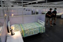 Journalists walk at a temporary field hospital set up at Asia World Expo in Hong Kong, Aug. 1, 2020.