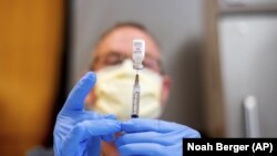 រូបឯកសារ៖ ឱសថការីម្នាក់កំពុងរៀបចាក់វ៉ាក់សាំងបង្ការជំងឺកូវីដ១៩ ផលិតដោយក្រុមហ៊ុនឱសថ Pfizer នៅក្រុង Sacramento រដ្ឋ California កាលពីថ្ងៃទី១២ ខែមករា ឆ្នាំ២០២១។