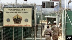 US military guards walk within Camp Delta military-run prison, at the Guantanamo Bay US Naval Base, Cuba, June 27, 2006.