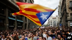 FILE - Demonstrators with "estelada," or the Catalonia independent flag, gather in protest in front of the Spanish police station in Barcelona, Spain, Oct. 3, 2017.