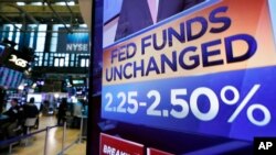 A screen on the floor of the New York Stock Exchange shows the rate decision of the Federal Reserve, March 20, 2019. 