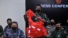 Seorang personel militer memegang baju keselamatan awak yang diyakini berasal dari kapal selam TNI AL KRI Nanggala 402 yang tenggelam saat jumpa pers di Bandara I Gusti Ngurah Rai, Bali, 25 April 2021. (Foto: Antara/Fikri Yusuf via REUTERS)