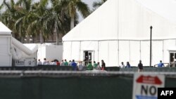 Migrant children who have been separated from their families can be seen in tents at a detention center in Homestead, Florida on June 27, 2019