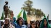 FILE - A Syrian Kurdish woman chants slogans during a rally in the countryside of the Hasakah province, Syria, June 27, 2020, to protest deadly Turkish offensives in northeastern areas of the country.