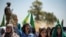 FILE - A Syrian Kurdish woman chants slogans during a rally in the countryside of the Hasakah province, Syria, June 27, 2020, to protest deadly Turkish offensives in northeastern areas of the country.