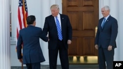 President-elect Donald Trump, center, and Vice President-elect Mike Pence, right, greet Mitt Romney, left, as he arrives at Trump National Golf Club Bedminster clubhouse in Bedminster, New Jersey, Nov. 19, 2016.