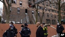 에릭 애덤스(오른쪽 세번째) 미국 뉴욕시장이 9일 아파트 화재 수습 현장을 둘러보고 있다. 