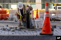 คนงานรายหนึ่งกำลังทำการรื้อพื้นผิวถนนที่มีการทาสีคำว่า Black Lives Matter ในกรุงวอชิงตัน ในวันจันทร์ที่ 10 มี.ค. 2568