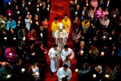 FILE - A bishop, center, accompanied by other clergy members, walks down the aisle during mass at the Cathedral of the Immaculate Conception, a government-sanctioned Catholic church in Beijing, China, March 31, 2018.