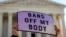 A pro-choice demonstrator holds a sign outside the United States Supreme Court as the court hears arguments over a challenge to a Texas law that bans abortion after six weeks in Washington, November 1, 2021. 