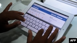 រូបឯកសារ៖ បុរសម្នាក់កំពុងប្រើប្រព័ន្ធអ៊ីនធឺណិតដើម្បីចូលក្នុងគណនីហ្វេសប៊ុកផ្ទាល់ខ្លួន នៅរាជធានីភ្នំពេញ ថ្ងៃទី ៩ ខែកញ្ញា ឆ្នាំ២០១១។ 